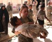 Injured child in Iraq War being carried by a U.S. Army Nurse