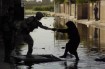 American soldiers assist an Iraqi woman across the street.