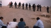 Palestinian children face a line of Israeli soldiers preparing to destroy their family homes at Al-Arakib.