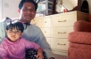 Four-year-old Yah Min, a victim of lead poisoning, sits with her father in their apartment in Fort Wayne, Indiana,