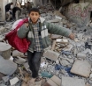 Boy making his way through a Gaza street after Israeli bombs wreaked havoc