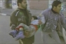 Men carry child from a school hit by air strike in Gaza.  UN Photo