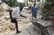 A Port-au-Prince man is in the process of shoveling, transporting and dumping the debris 