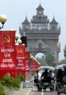 Tuk-tuks drive towards the Patuxay tower in the center of Vientiane, March 17, 2006.