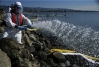 Oil lifting chemicals being applied to rocks.  U.S. Coast Guard photo