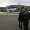 Photo of OSP Sergeant Gordon Larson with Senior Trooper Johnson's wife and son watching Air Life prepare for takeoff from Blue Mountain Hospital. 