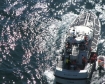 A 47-foot motor lifeboat crew from Coast Guard Station Quillayute River, Wash., brings aboard two men and their life raft after their vessel sank