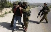 Israeli troops detain an international peace activist during a protest over land confiscation in Beit Ummar village near Hebron