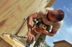 Airman 1st Class Tyler Saulsgiver from Travis Air Force Base, Calif. installs a door on a newly built dining facility expansion at a combat outpost, Afghanistan, May 23, 2011.