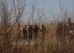 Soldiers stand guard  near three people were found, on the outskirts of Ciudad Juarez, February 25