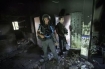 Israeli policemen inspect a burnt mosque after it was torched in the Bedouin village of Tuba Zangaria (AFP/File, Menahem Kahana)