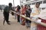 police man checks the voting slip of Bangladeshi voters