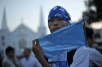 A Burmese activist displays a peace flag at the start of a walk from Rangoon to the Kachin rebel stronghold of Laiza