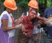 Muslim Kaman lady brutally slaughtered by Rakhines in front of her house; her is lingering near by obviously in shock.