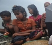 Rohingya refugees cross the Naf River in a downpour