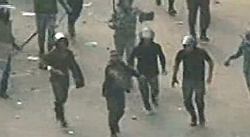 A member of the Egyptian government forces fires a round at unarmed protestors in Cairo's Tahrir Square.