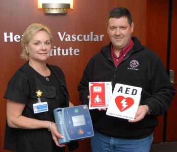 Providence Heart and Vascular Institute administrator Kristy Wayson and Cooper Spur Volunteer Ski Patrol member Jason Wilkins display the donated AED.