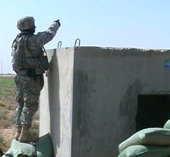 A U.S. Army soldier in Iraq motions toward an approaching individual while on patrol. 