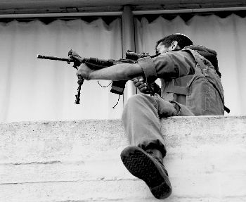 Israeli soldier fires his weapon near the border between Israel and Palestine